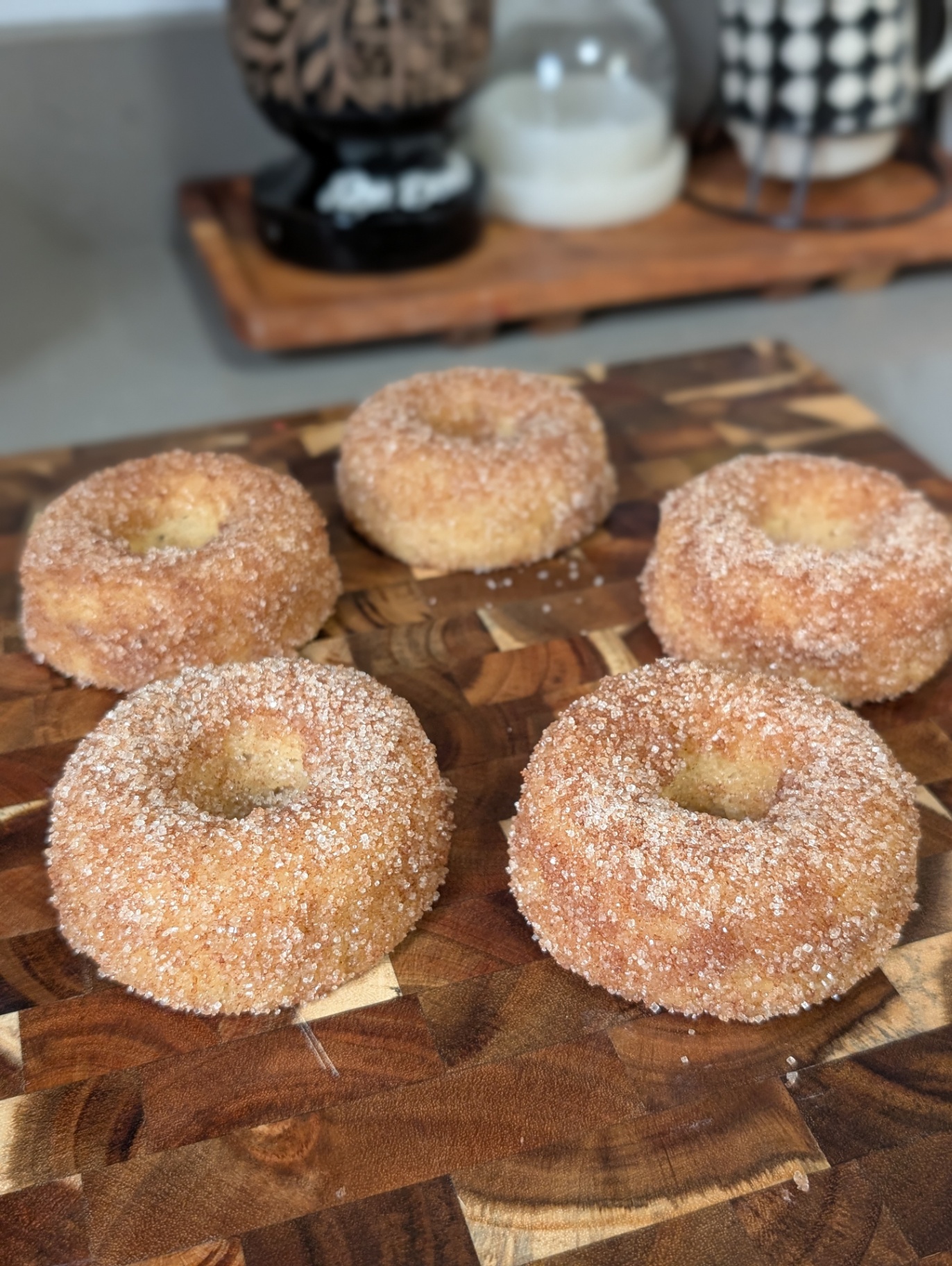 Sugar-dusted apple cider donuts on a wooden board